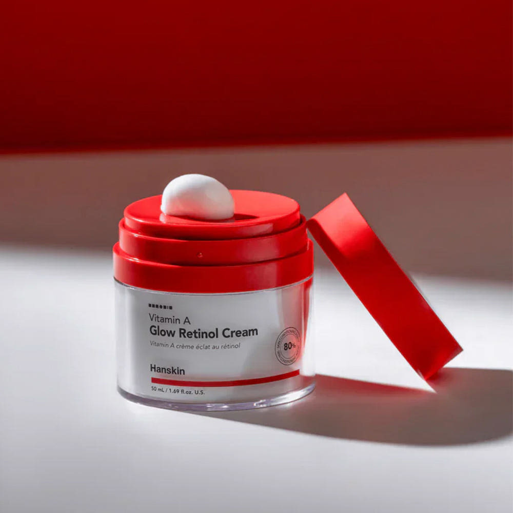 AgelessBeauty3000.com Red and white skincare cream jar with a red lid on a light gray background