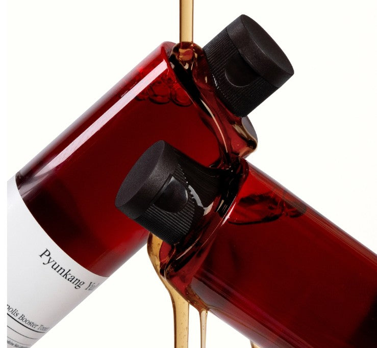 AgelessBeauty3000.com Pyunkang Yul | Red Ginseng Propolis Booster Toner
Red bottle with black cap and white label, pouring liquid.