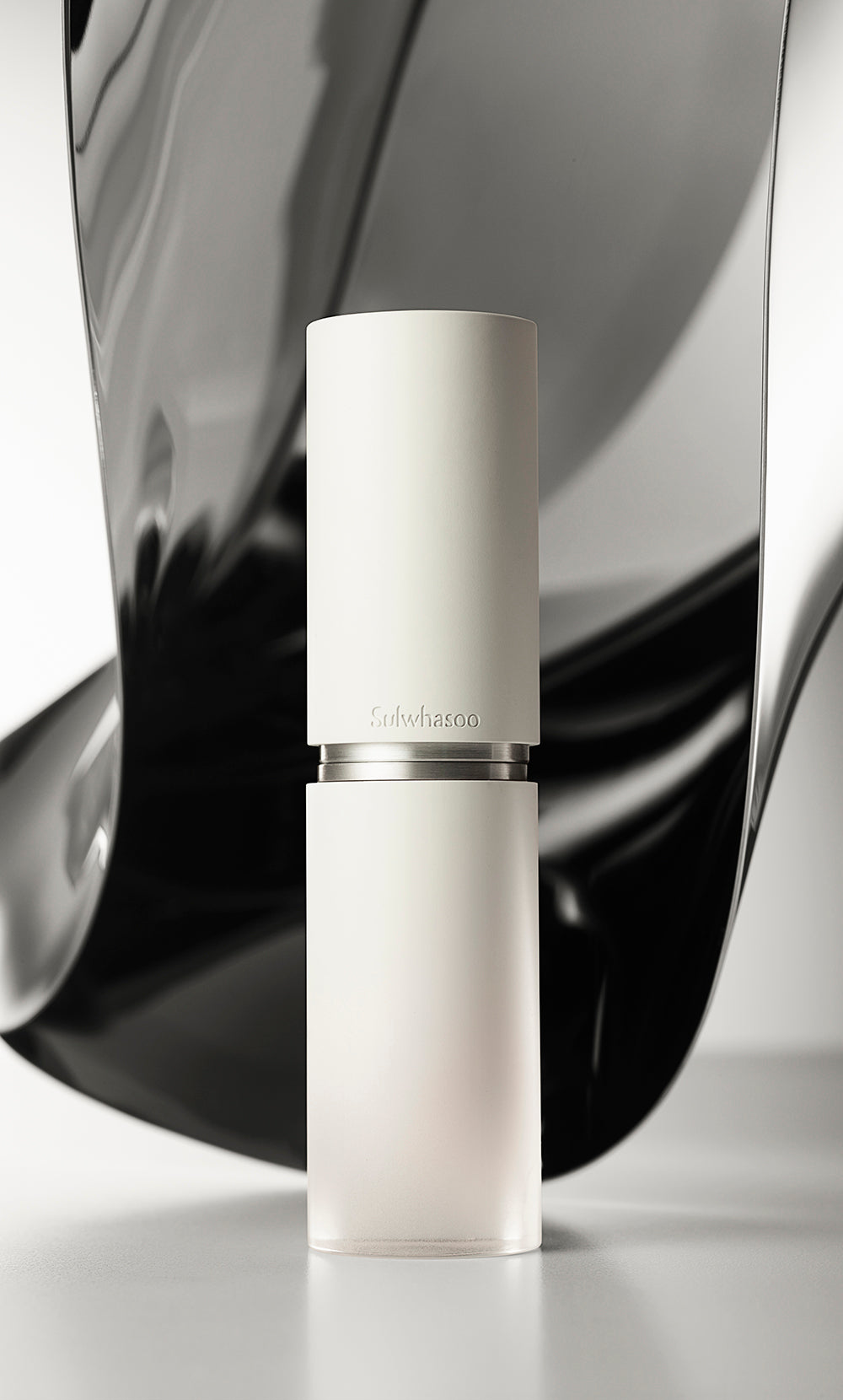 AgelessBeauty3000.com  Sulwhasoo | The Ultimate S Serum    White skincare bottle with silver cap on a reflective black and white background