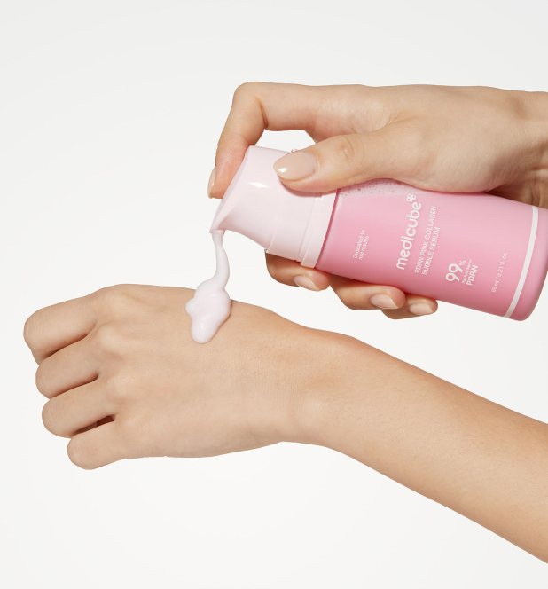 AgelessBeauty3000.com  medicube  | PDRN Pink Collagen Bubble Serum    Hand applying pink cream from a bottle labeled 'Medichreme' to another hand on a white background
